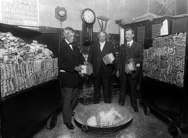 Destruction committee filling the maceration cylinders with $4.4 million in cash to be destroyed.