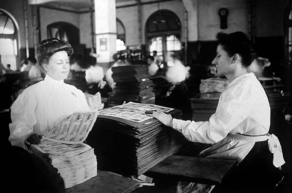 Staff removing national banknote sheets interleaved between heavier stock after the ink from the face printings had set.